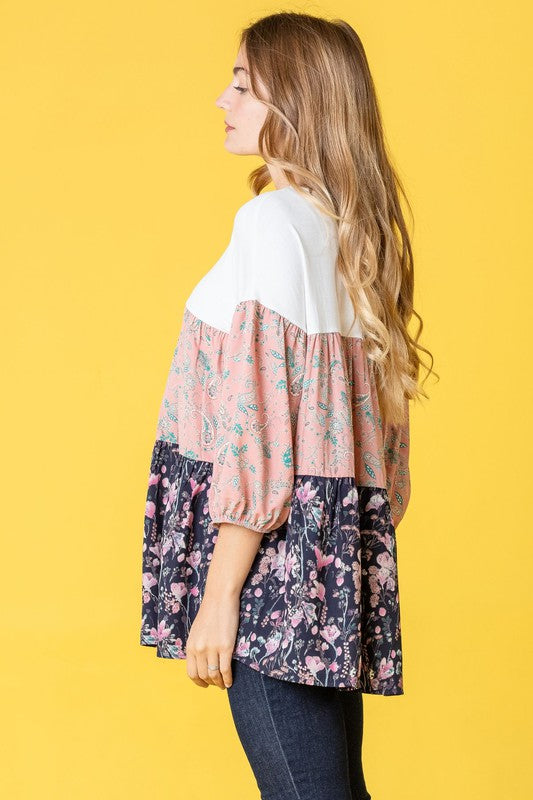 A woman elegantly poses against a vibrant yellow background, showcasing a Three Tiered Bishop Sleeve Paisley Floral Tunic.