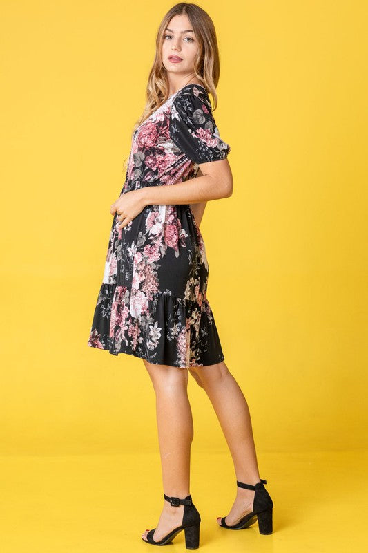 A woman in a Surplice Tiered Midi Dress stands against a vibrant yellow background, her style epitomizing the charming fashion trends of the United States.