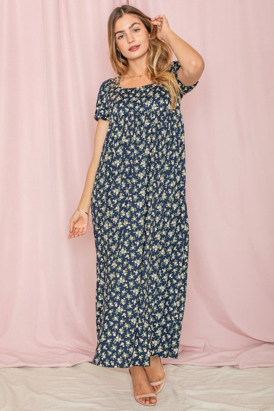 Woman in a Floral Square Neck Puff Sleeve dress stands against a pink backdrop.