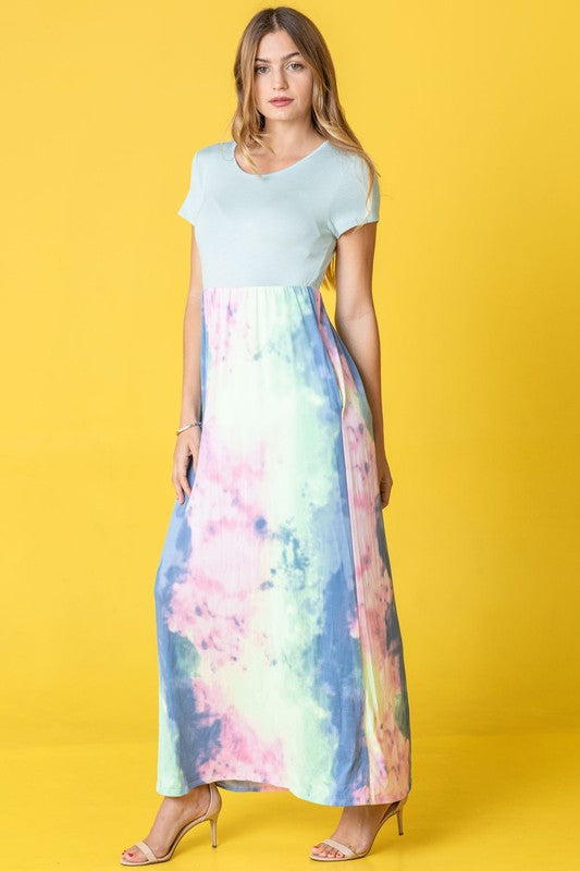 A woman wearing the Two Tone Tie Dye Maxi Dress, which is made from polyester spandex and features short sleeves, poses against a vibrant yellow background.