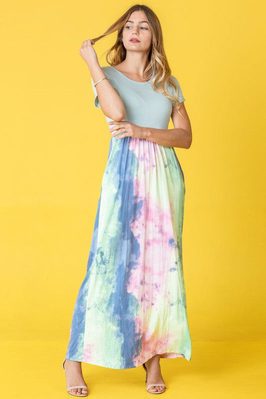 A woman wearing the Two Tone Tie Dye Maxi Dress, which is made from polyester spandex and features short sleeves, poses against a vibrant yellow background.