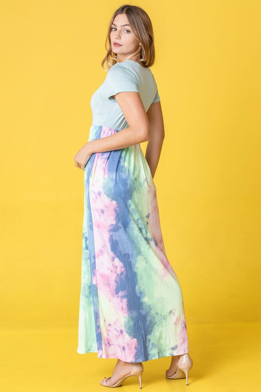 A woman wearing the Two Tone Tie Dye Maxi Dress, which is made from polyester spandex and features short sleeves, poses against a vibrant yellow background.