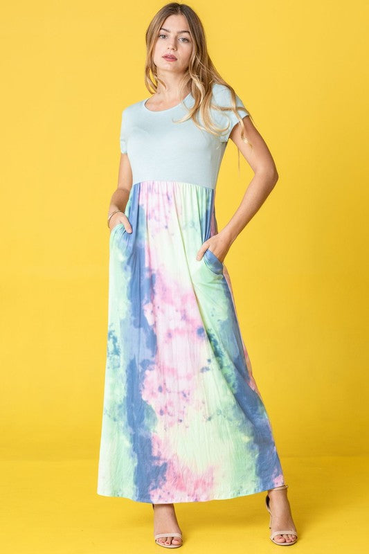 A woman wearing the Two Tone Tie Dye Maxi Dress, which is made from polyester spandex and features short sleeves, poses against a vibrant yellow background.