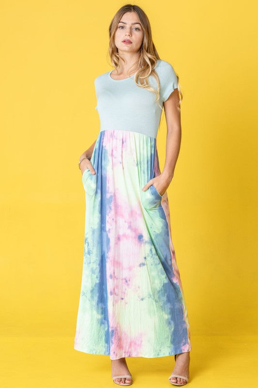 A woman wearing the Two Tone Tie Dye Maxi Dress, which is made from polyester spandex and features short sleeves, poses against a vibrant yellow background.