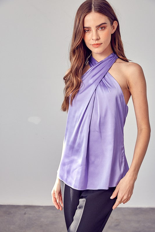 A woman wearing the stylish Cross Neck Top in lavender, paired with black pants, stands against a neutral background.