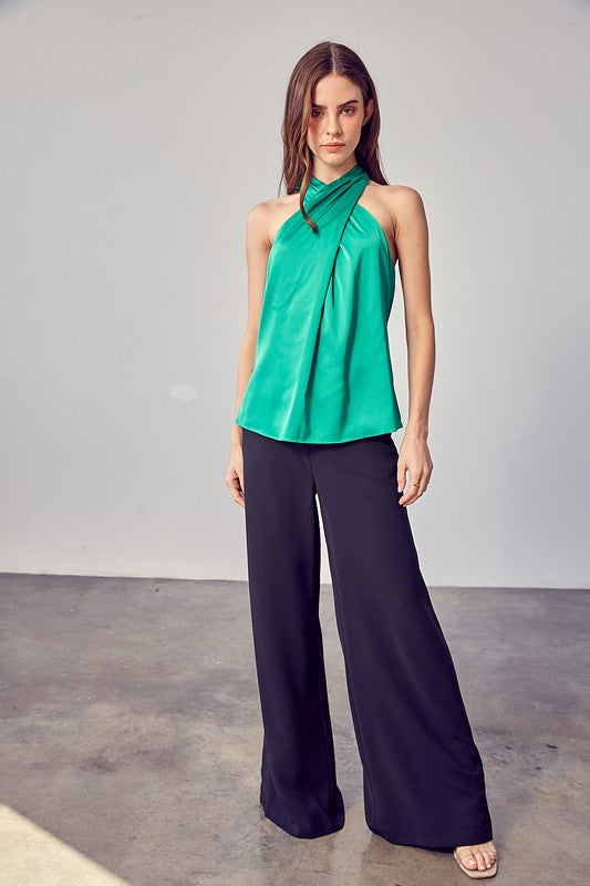 A woman wearing the stylish Cross Neck Top in lavender, paired with black pants, stands against a neutral background.