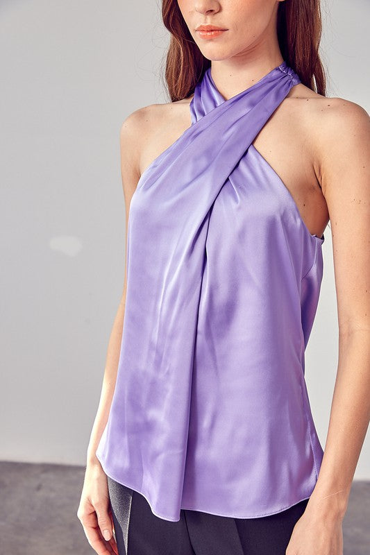 A woman wearing the stylish Cross Neck Top in lavender, paired with black pants, stands against a neutral background.