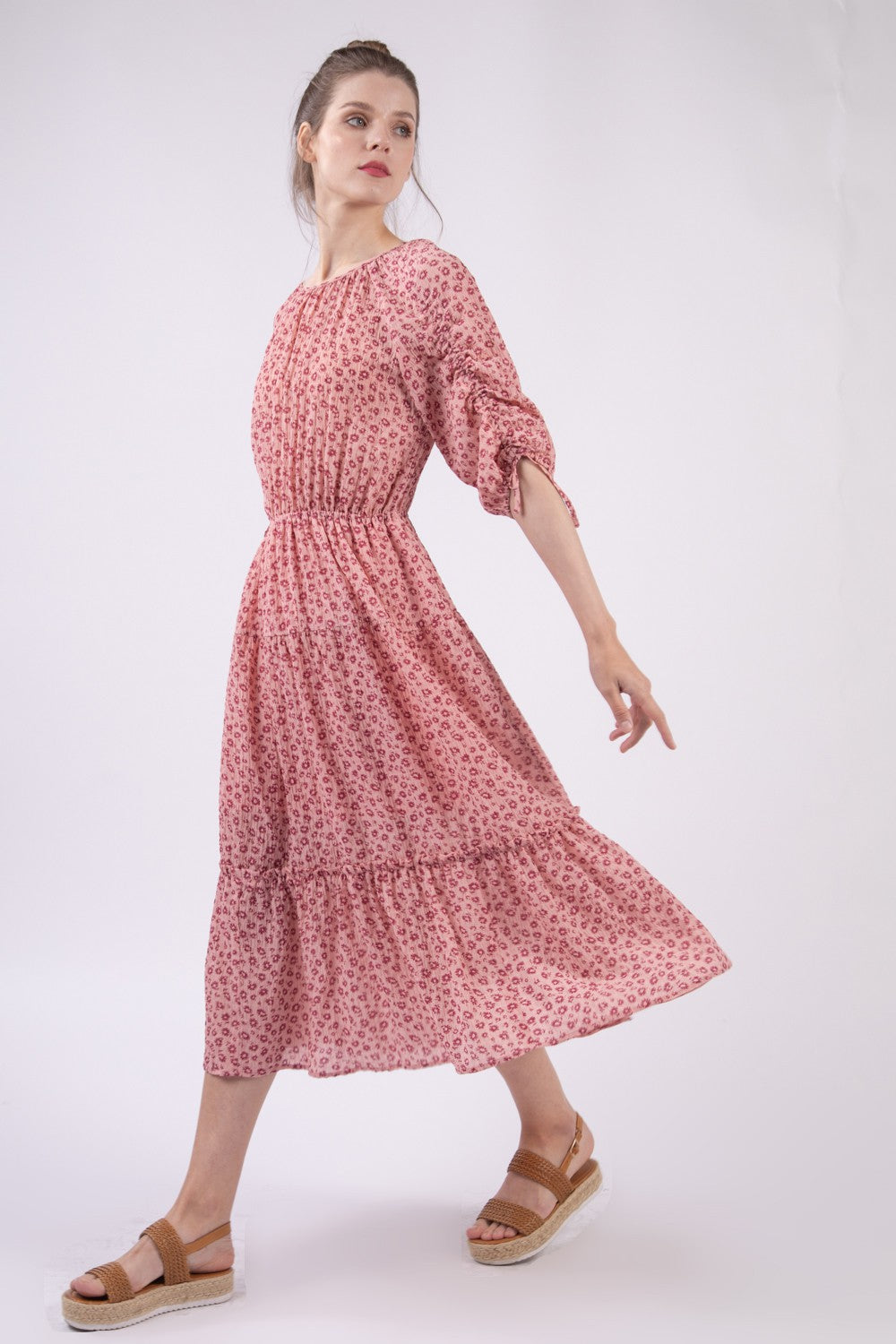 A woman wearing the VERY J Floral Round Neck Tiered Midi Dress and sandals poses gracefully against a plain white background.