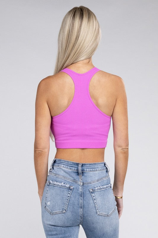Woman wearing a pink Lanae Ribbed Cropped Racerback Tank Top and blue jeans standing against a neutral background.