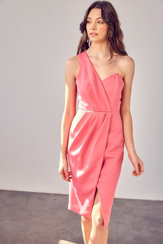 A woman models the "One Shoulder Overlap Dress" in a stylish pink design, highlighting its contemporary fashion with an asymmetrical hem and subtle overlap detail, set against a plain background.