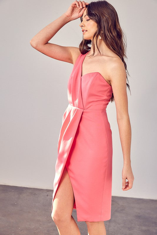 A woman models the "One Shoulder Overlap Dress" in a stylish pink design, highlighting its contemporary fashion with an asymmetrical hem and subtle overlap detail, set against a plain background.