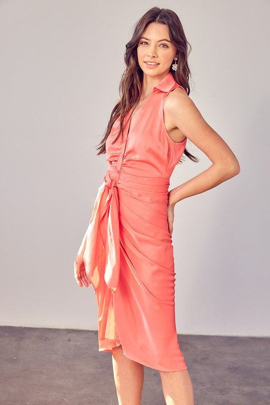 A woman wearing the Sleeveless Collar Front Tie Dress in coral, standing against a plain backdrop.