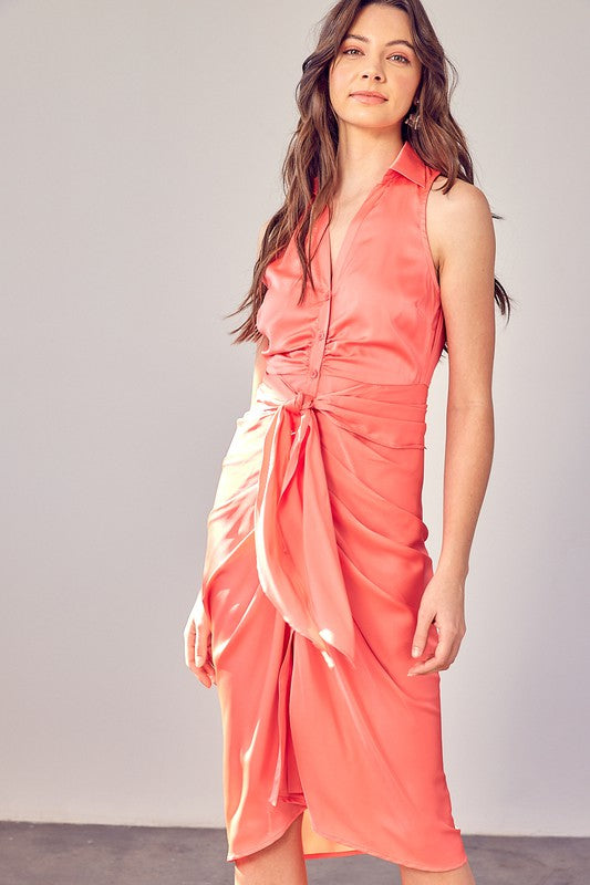 A woman wearing the Sleeveless Collar Front Tie Dress in coral, standing against a plain backdrop.