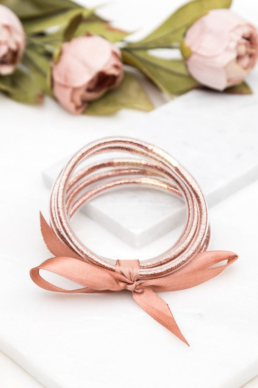 Woman wearing a white blouse and Glitter Jelly Bangle Bracelets.