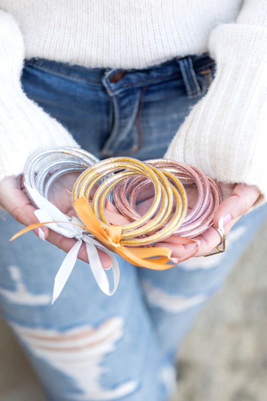 Woman wearing a white blouse and Glitter Jelly Bangle Bracelets.