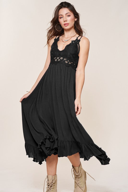 A woman wearing a Long Slip Dress with black lace trim and tan boots poses against a plain background.