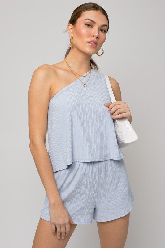 Person wearing the Sleeveless One Shoulder Layered Top Romper in a chic light blue shade, perfect for a stylish summer outfit, standing against a neutral background.