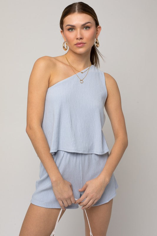 Person wearing the Sleeveless One Shoulder Layered Top Romper in a chic light blue shade, perfect for a stylish summer outfit, standing against a neutral background.