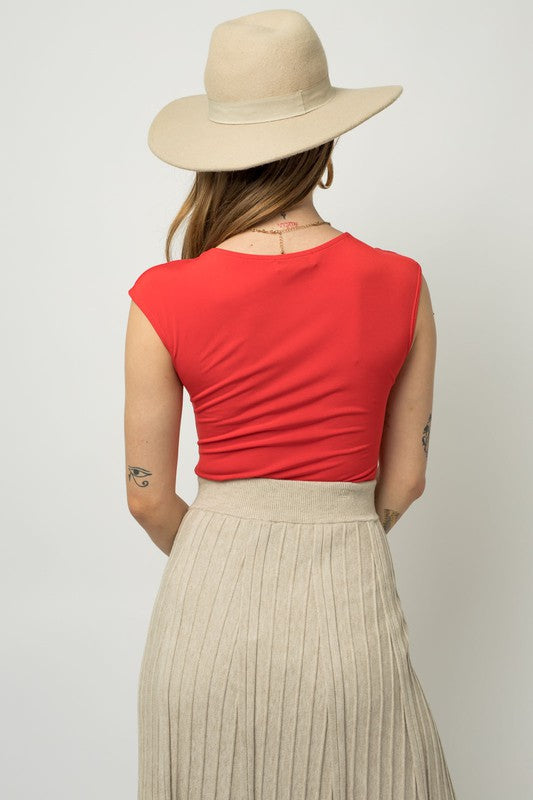 A person wearing a Cap Sleeve Square Neck Bodysuit and jeans holds a black handbag, showcasing a true fashion essential.