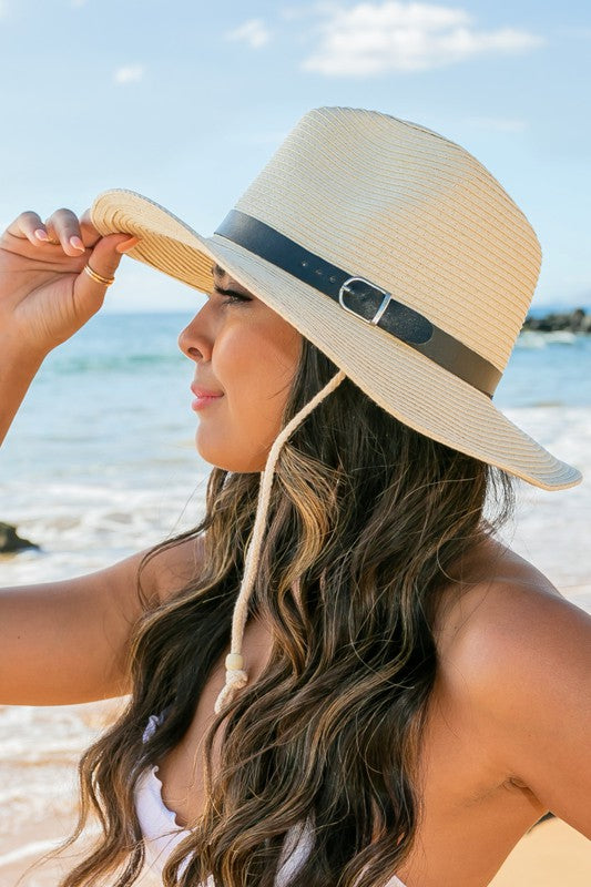 Woman holding a Drawstring Panama Hat on the beach.