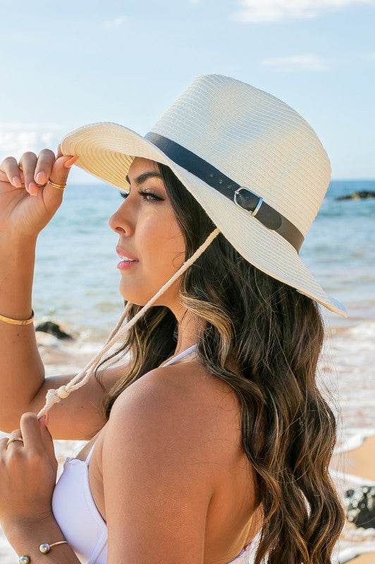 Woman holding a Drawstring Panama Hat on the beach.