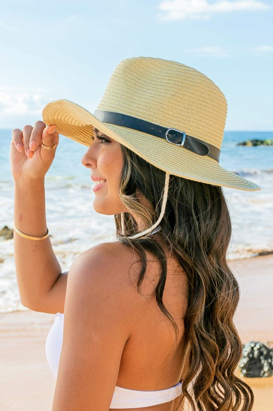 Woman holding a Drawstring Panama Hat on the beach.