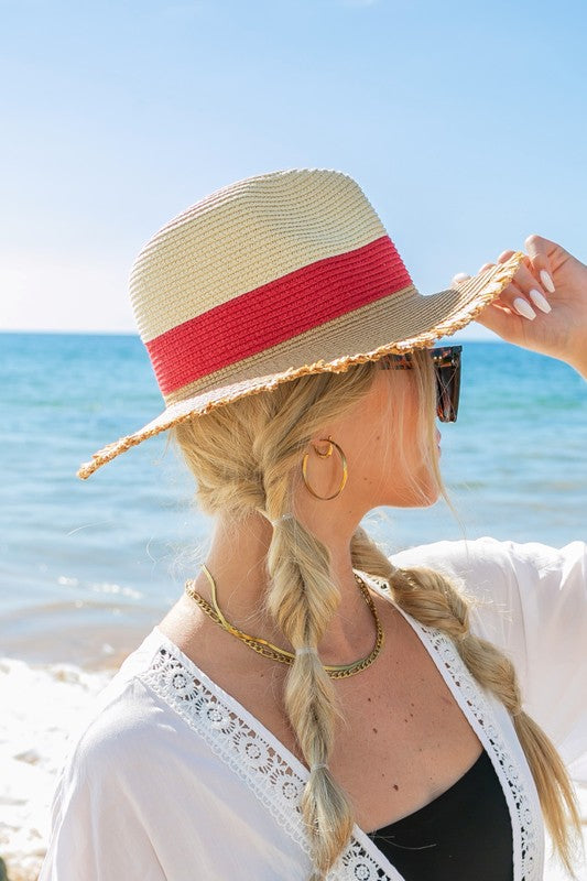 Woman smiling on the beach while holding onto her Fray-Edge Color Block Straw Panama Fedora Hat.
