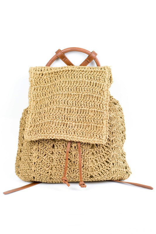 A person wearing a straw hat and white tank top carries the elegant Woven Straw Backpack, featuring charming PU leather straps.