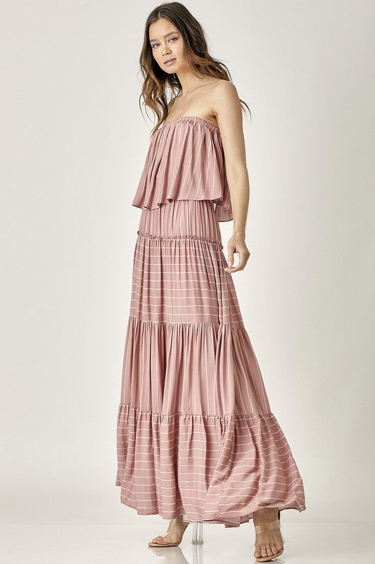 A woman exudes elegance in the Pin Stripe Print Tube Maxi Dress with its subtle pin stripe design.