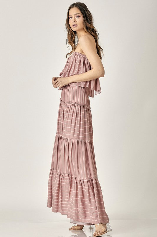 A woman exudes elegance in the Pin Stripe Print Tube Maxi Dress with its subtle pin stripe design.