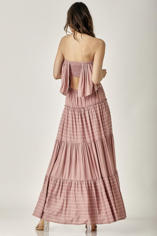 A woman exudes elegance in the Pin Stripe Print Tube Maxi Dress with its subtle pin stripe design.