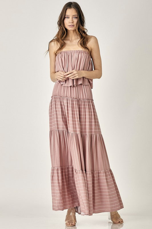 A woman exudes elegance in the Pin Stripe Print Tube Maxi Dress with its subtle pin stripe design.