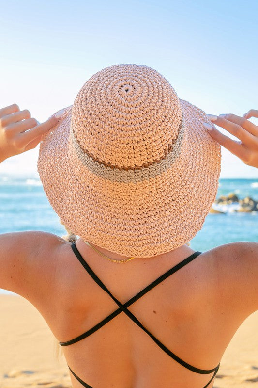 Woman smiling with sunglasses and a Stripe Accent Straw Bucket Hat at the beach.