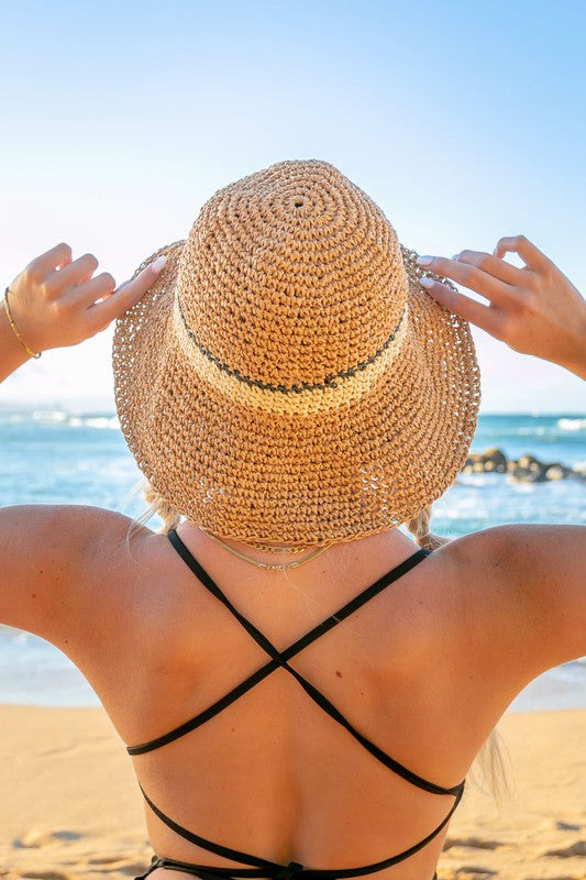 Woman smiling with sunglasses and a Stripe Accent Straw Bucket Hat at the beach.