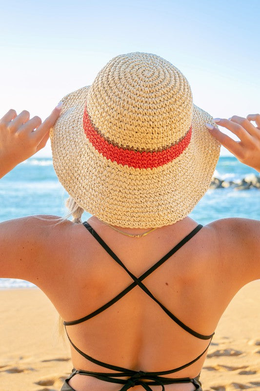 Woman smiling with sunglasses and a Stripe Accent Straw Bucket Hat at the beach.