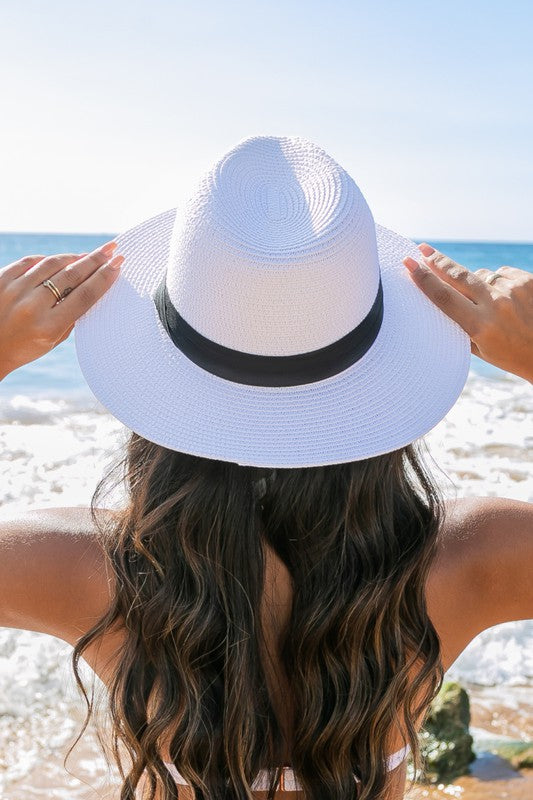 Young woman in a Classic Straw Panama Fedora Hat with a black cotton band smiling on the beach.
