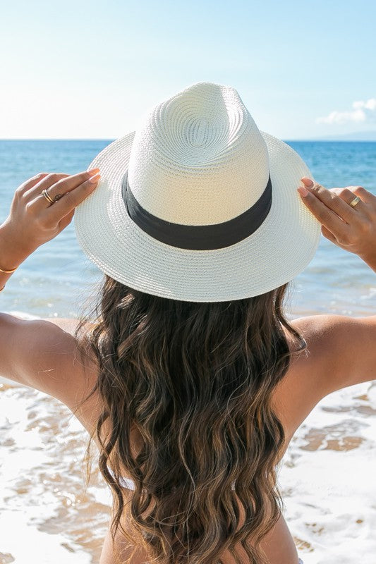 Young woman in a Classic Straw Panama Fedora Hat with a black cotton band smiling on the beach.