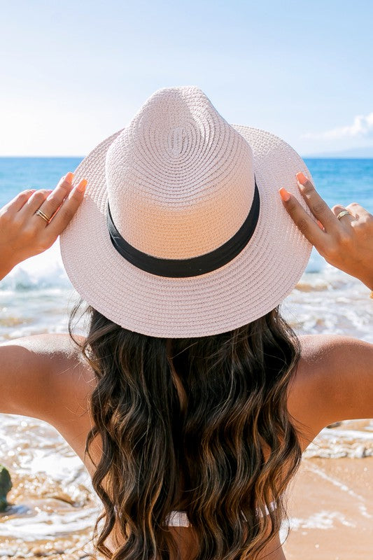 Young woman in a Classic Straw Panama Fedora Hat with a black cotton band smiling on the beach.