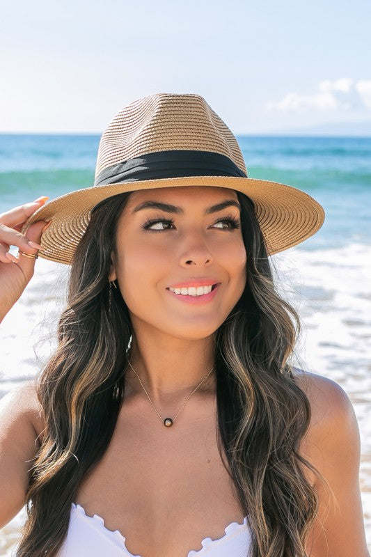Young woman in a Classic Straw Panama Fedora Hat with a black cotton band smiling on the beach.