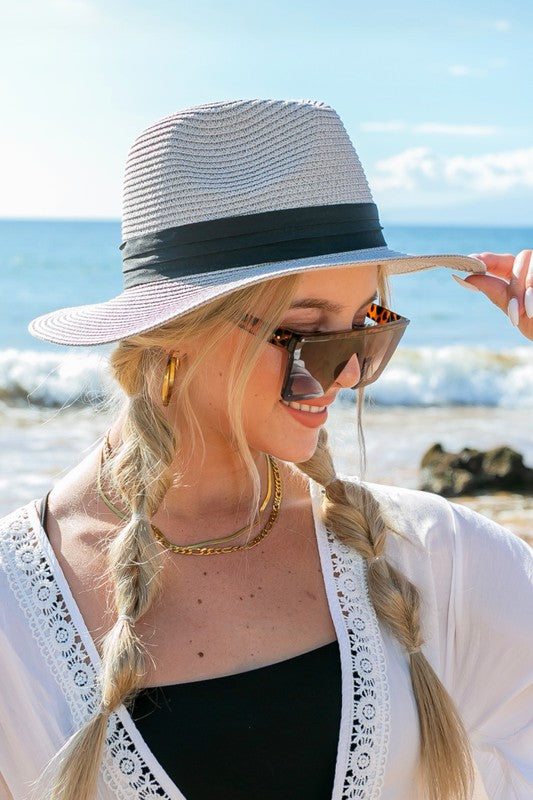 Young woman in a Classic Straw Panama Fedora Hat with a black cotton band smiling on the beach.