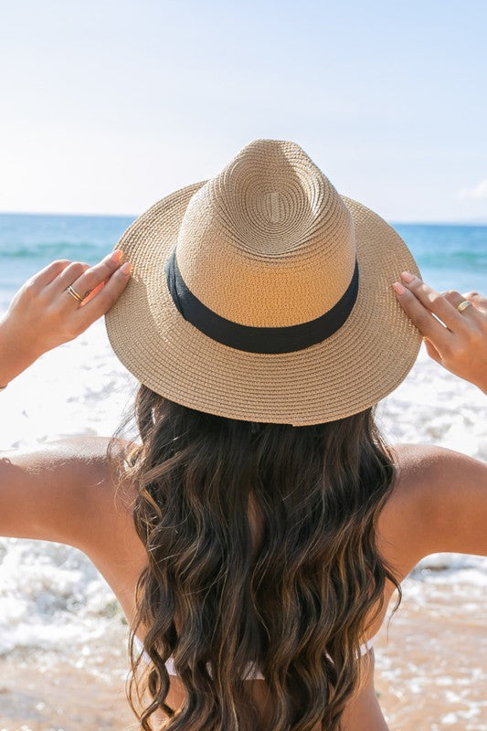 Young woman in a Classic Straw Panama Fedora Hat with a black cotton band smiling on the beach.