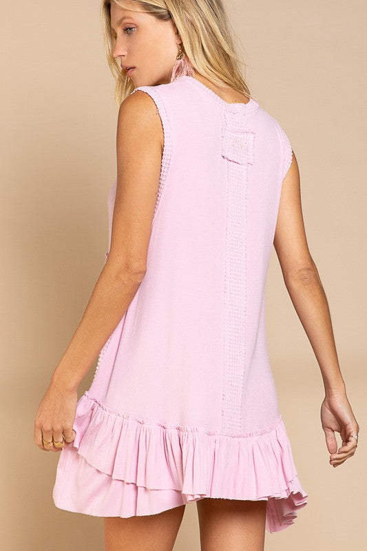 A woman in a Sleeveless Ruffle Hem Dress featuring textured patterns poses against a beige background. Her long blonde hair flows down, and she wears large pink earrings, emphasizing the baby doll fit that perfectly complements her style.