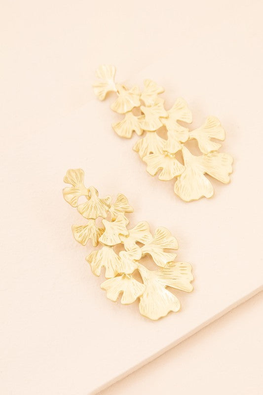 Adiantum Drop Earrings with a tiered leaf design, finished in matte gold and set on a light beige background, complete with a sterling silver post.