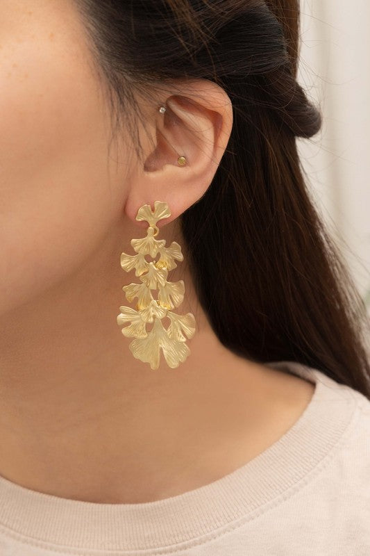 Adiantum Drop Earrings with a tiered leaf design, finished in matte gold and set on a light beige background, complete with a sterling silver post.