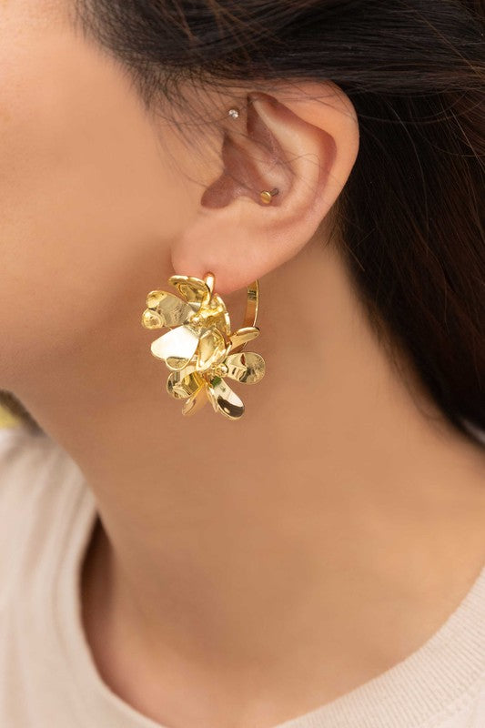 The Botanist Hoop Earrings showcase exquisite gold floral designs on a light-colored surface, beautifully enhanced with 10k gold plating.