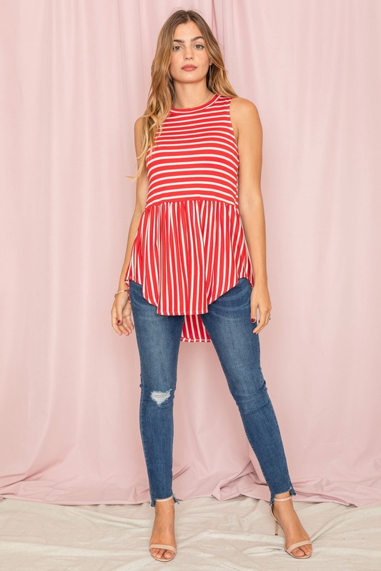 Against a pink background, a woman in a sleeveless blue and white striped top captures the casual elegance of the Stripe High Waist Tunic, proudly made in the United States.