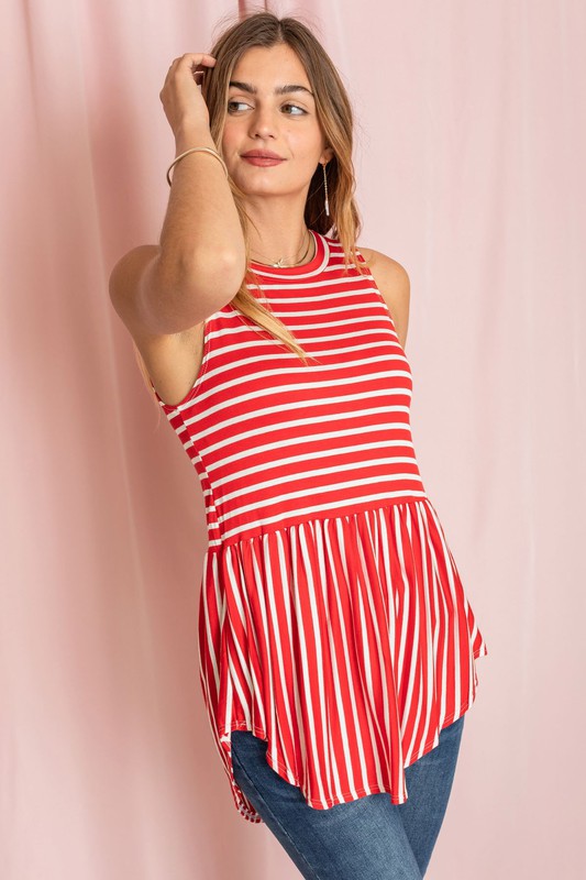 Against a pink background, a woman in a sleeveless blue and white striped top captures the casual elegance of the Stripe High Waist Tunic, proudly made in the United States.