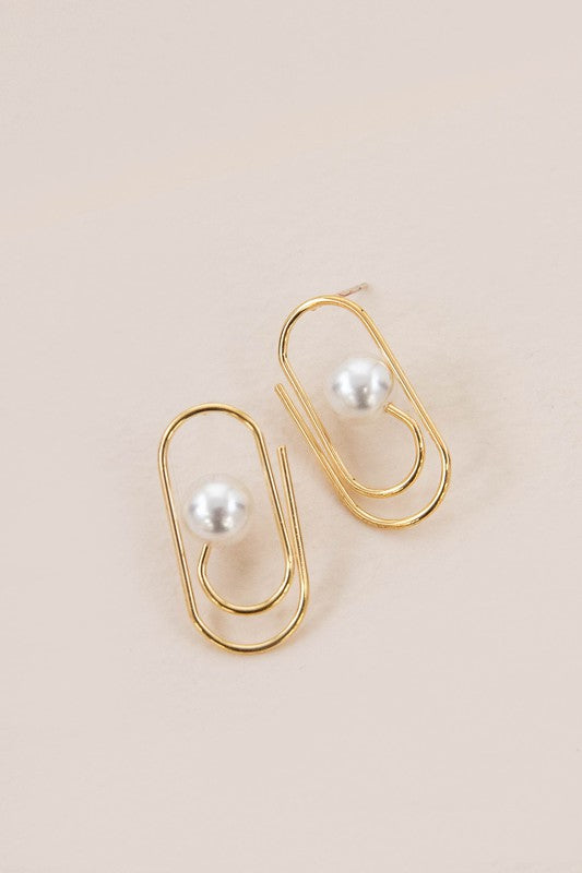 The Workflow Post Earrings showcase a central pearl elegantly positioned on a beige backdrop, each piece secured by a sterling silver post.