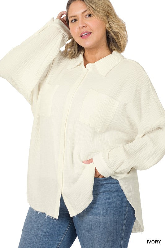 A person wearing the Plus Oversized Raw Edge Shirt in dusty blush over a white top and jeans, posing with one hand near their chin, capturing the essence of a casual wardrobe look.