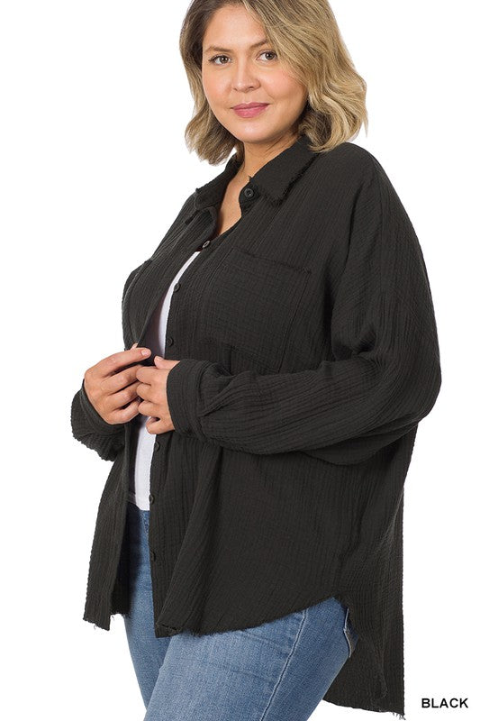 A person wearing the Plus Oversized Raw Edge Shirt in dusty blush over a white top and jeans, posing with one hand near their chin, capturing the essence of a casual wardrobe look.